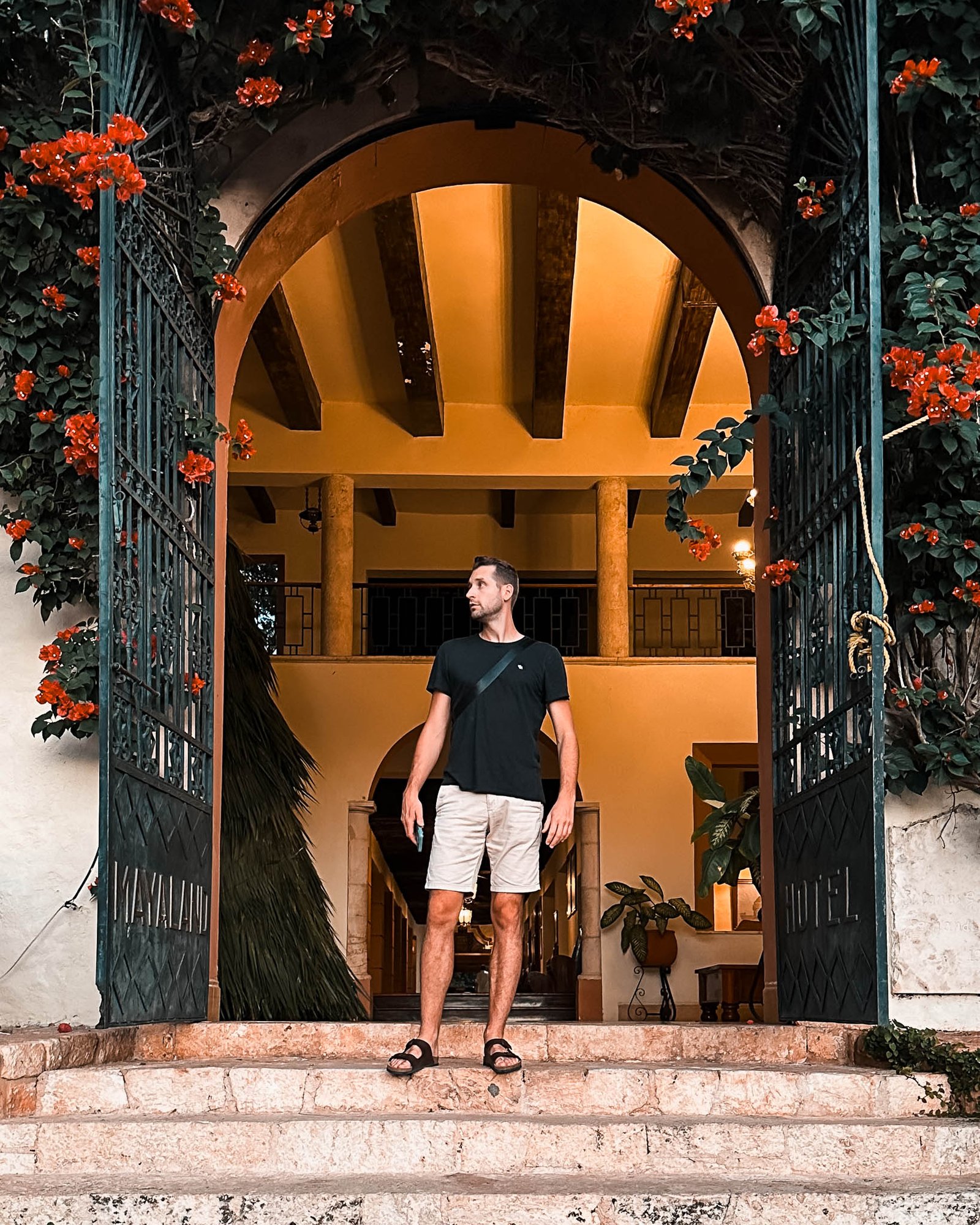 Ein Mann steht in der Mitte des Tores das ins Hotel führt