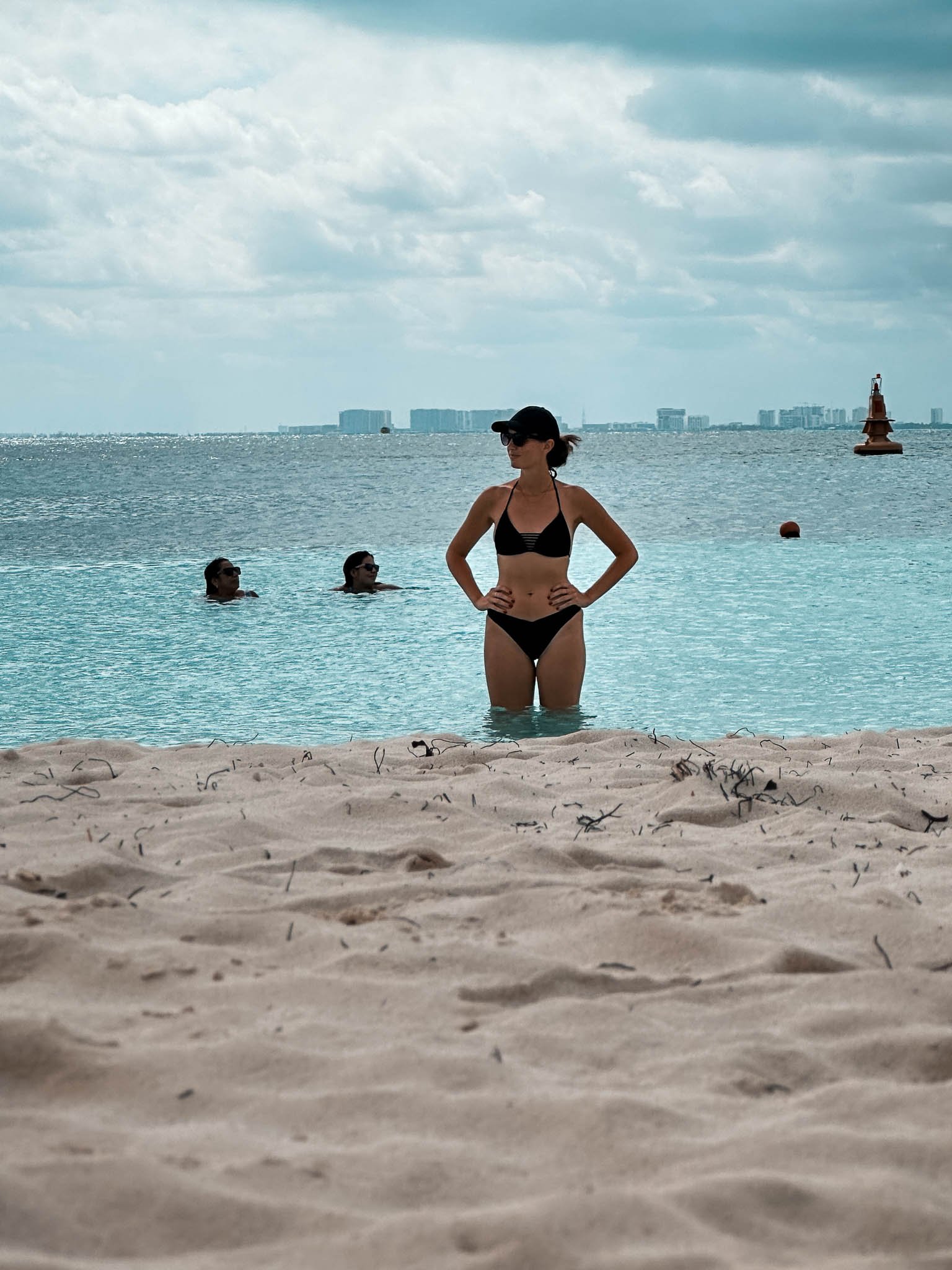 Eine Frau steht am Strand mit den Beinen im Wasser