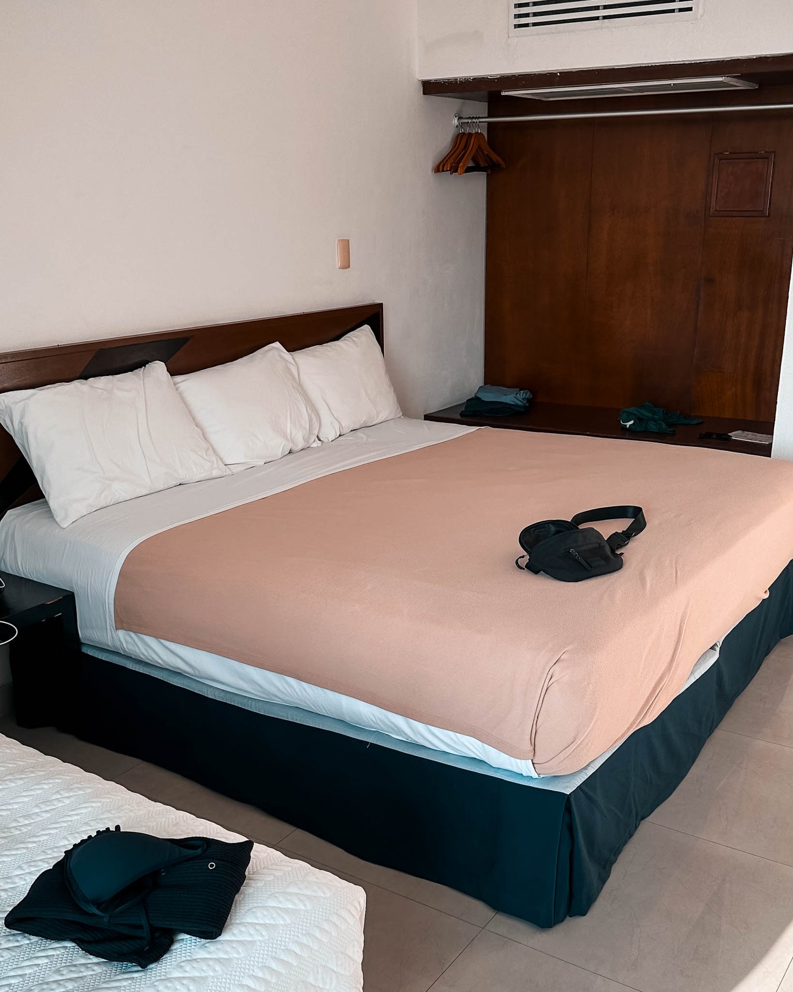 Großes Doppelbett und brauner Schrank dahinter im Hotelzimmer