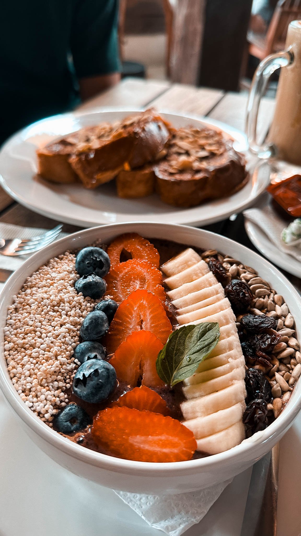 Große Frühstücksbowl und French Toast auf einem Teller