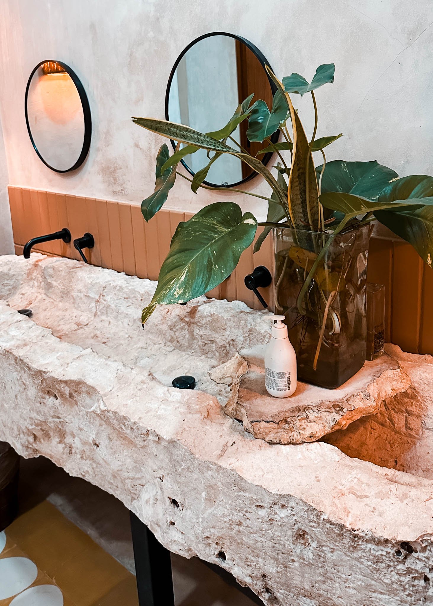 Großes Steinwaschbecken im Bereich der Toiletten schön mit Pflanzen verziert