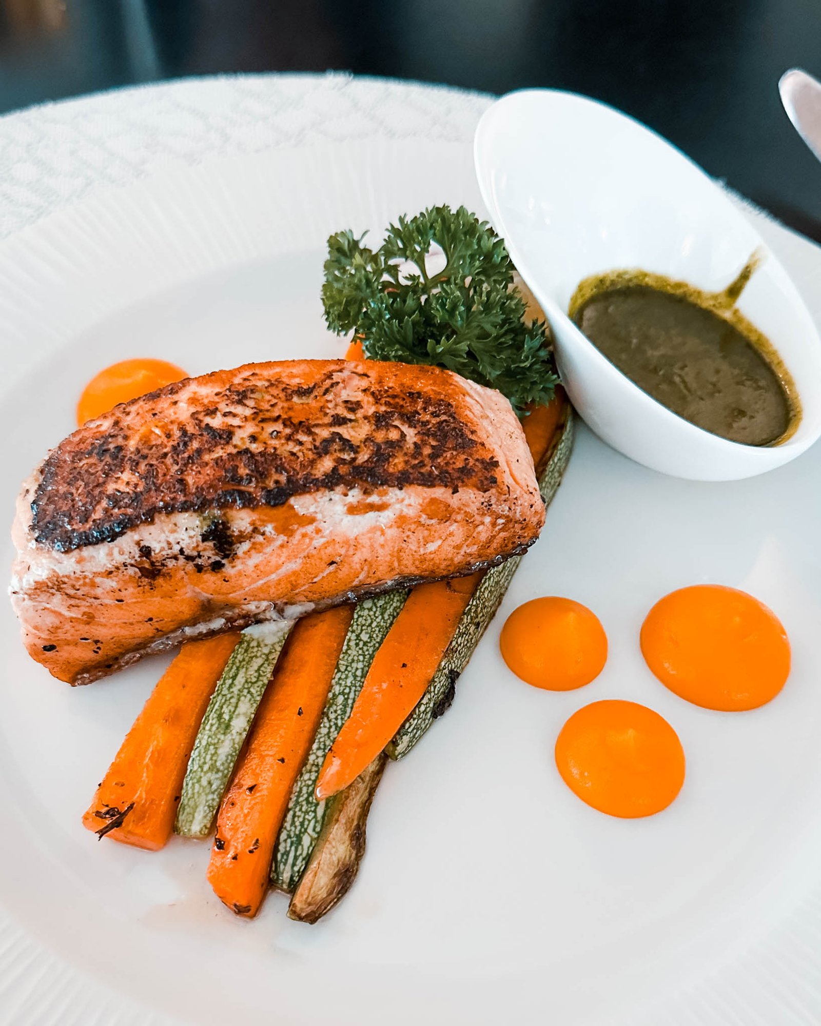 gebratener Lachs auf einem Teller mit Gemüse