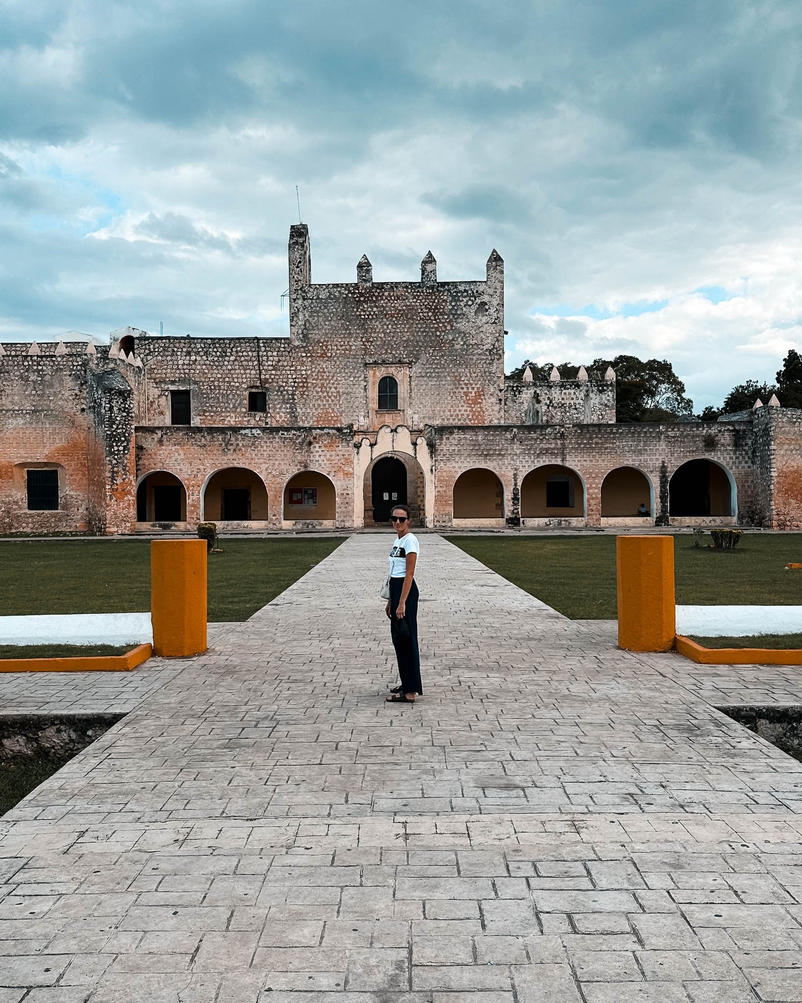 Eine Frau steht vor dem alten Kloster in Valladolid