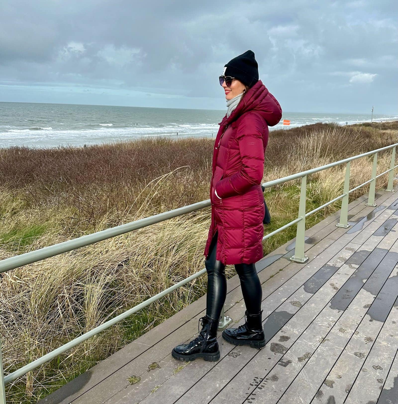 Junge Frau in roter Jacke am Stranddamm in Domburg