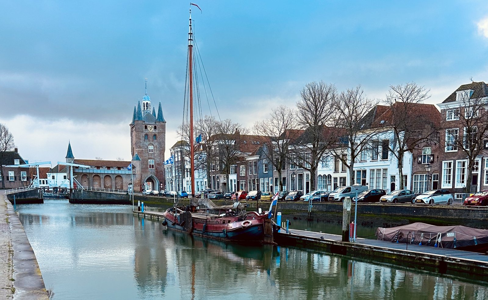 Blick auf den kleinen Hafen in der Innenstadt von Zieriksee mit Turm im Hintergrund und altem Segelboot