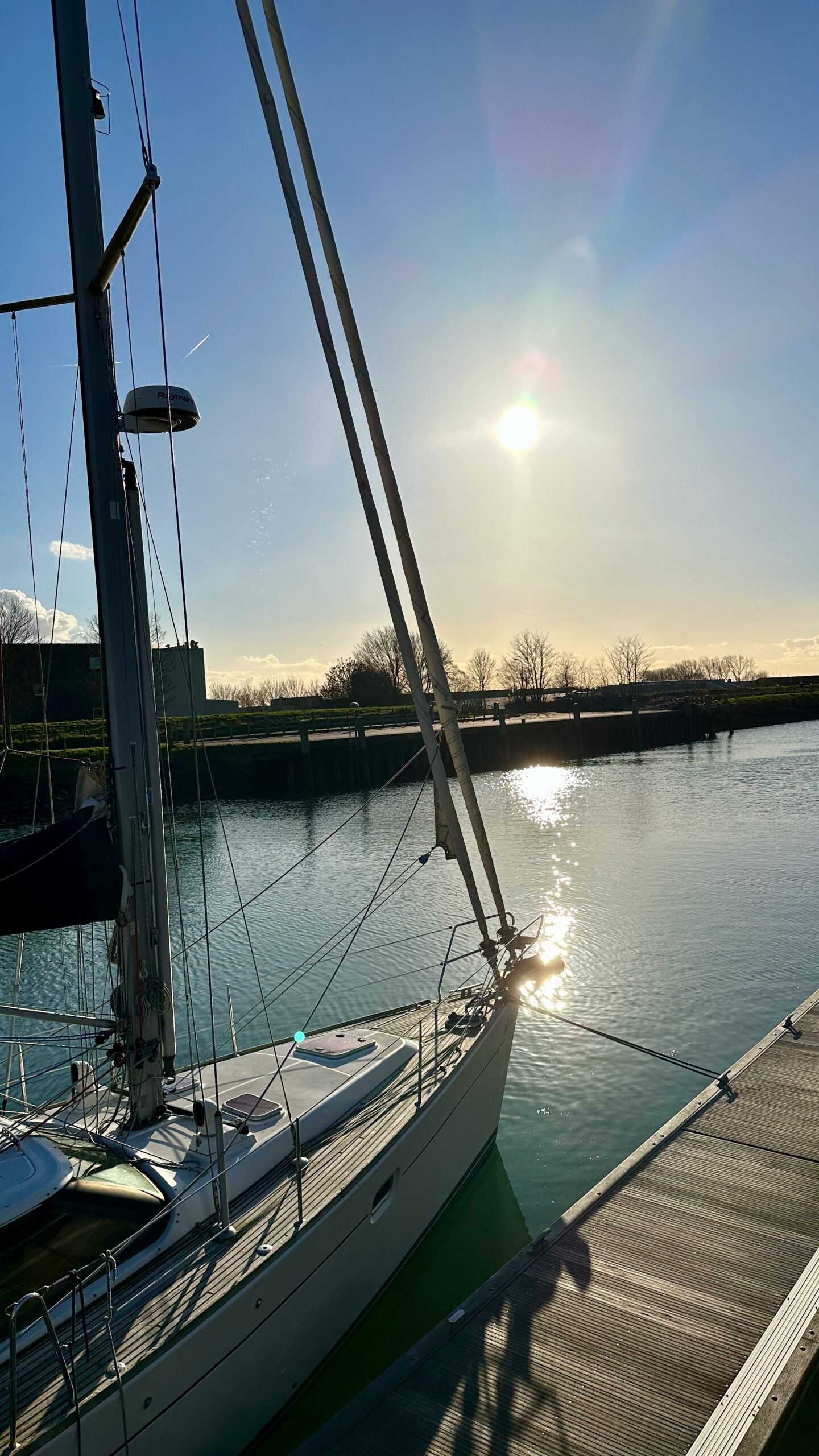 Blick auf den Kanal der zum Yachthafen führt mit einem Segelboot im Vordergrund