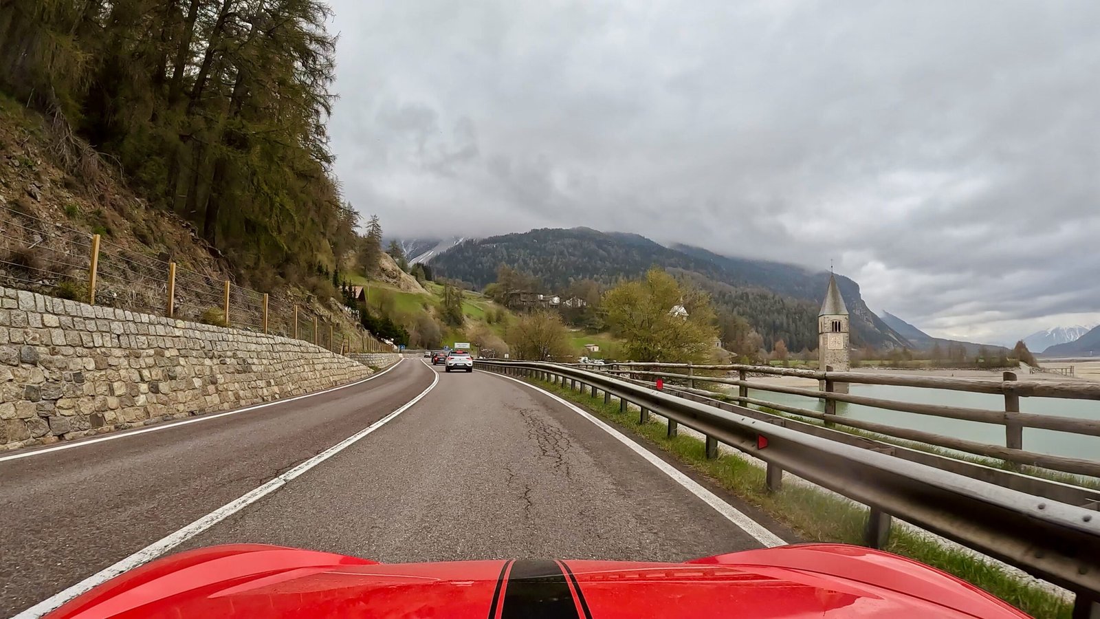 Fahrt am Reschenpass mit Blick des Fahrers auf den Reschensee und seinen versunkenen Turm